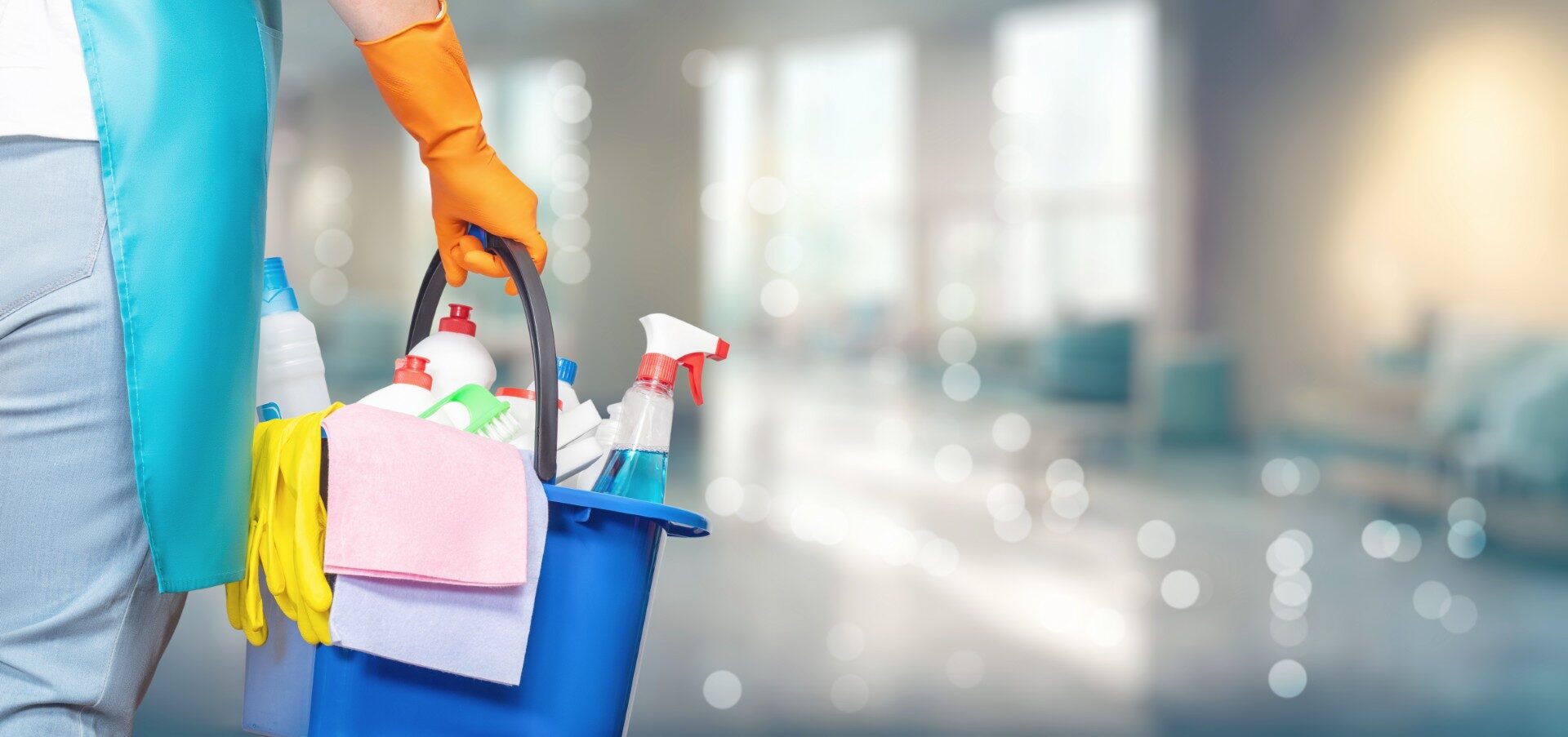 Woman wearing rubber gloves holding cleaning products